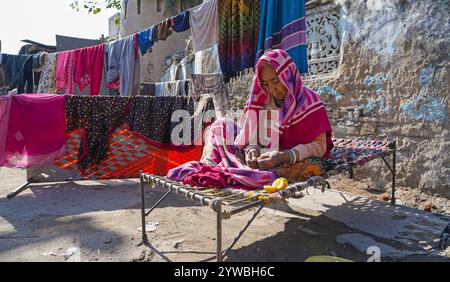 Beawar, Rajasthan, India, 10 dicembre 2024: Una vecchia donna coperta di abiti caldi mentre siede sotto la luce del sole per riscaldarsi durante una fredda giornata invernale a Beawar. Crediti: Sumit Saraswat / Alamy Live News Foto Stock