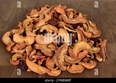 Fette di frutta secca miste. Frutta biologica essiccata al sole. Mele secche, pere e frutta biologica su fondo di legno. Foto Stock