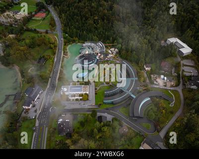 Vista aerea della sede centrale della Red Bull a Fuschl am SEE, in Austria, con un'atmosfera nebbiosa, che cattura la pista da corsa motoristica e i suoi dintorni Foto Stock