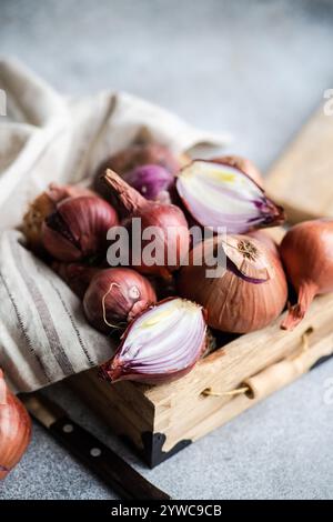 Primo piano di cipolle bianche e rosse assortite su un tagliere di legno Foto Stock