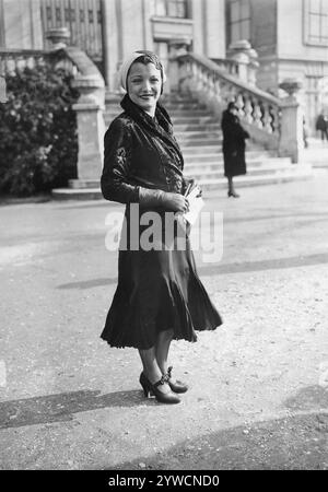 Signora in cappotto alla moda e copricapo alle corse di cavalli Auteuil., Parigi, Francia, 1932 Foto Stock