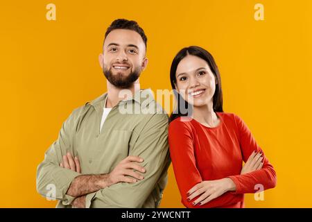 Abbina le pose in outfit coordinati su uno sfondo giallo brillante Foto Stock