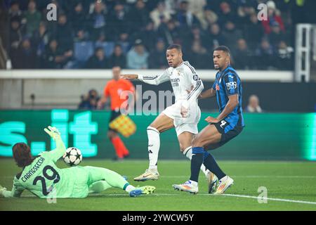 Bergamo, Italia. 10 dicembre 2024. Il tiro di Kylian Mbappe (C) del Real Madrid è bloccato dal portiere dell'Atalanta Marco Carnesecchi (L) durante la partita di UEFA Champions League tra l'Atalanta e il Real Madrid a Bergamo, Italia, 10 dicembre 2024. Crediti: Li Jing/Xinhua/Alamy Live News Foto Stock