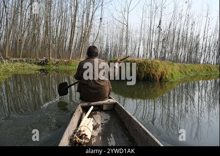 Srinagar, India. 10 dicembre 2024. SRINAGAR, INDIA - 10 DICEMBRE: Un uomo affonda la sua barca nelle acque del lago Anchar il 10 dicembre 2024 nella periferia di Srinagar, India. Cold Wave afferra il Kashmir, come Srinagar Records Season's Coldest Night at Minus 5,4 gradi celsius. (Foto di Waseem Andrabi/Hindustan Times/Sipa USA) credito: SIPA USA/Alamy Live News Foto Stock