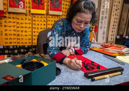 Vietnam, Hanoi, 2024-02-14, Tet festival, Capodanno cinese, calligrafia, donna calligrafa, tempio della letteratura, fotografia di Jean-Yves Bardin Foto Stock