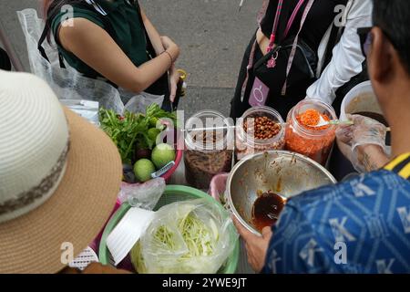 Il cibo di strada prepara SomTum o insalata di papaya con ingredienti quali pepe, pomodoro, limone e aglio è il cibo tradizionale thailandese. Foto Stock