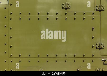 Struttura di fondo industriale astratta con bulloni di parete in acciaio cachi, dettagli del treno corazzato sovietico del tempo della seconda guerra mondiale Foto Stock