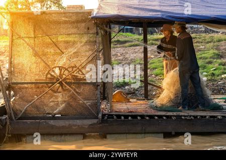 Pescatori locali che tirano la rete da pesca dal fiume a Tonle SAP, in Cambogia Foto Stock