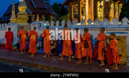 Monaci che raccolgono elemosine al mattino a Luang Prabang, Laos Foto Stock