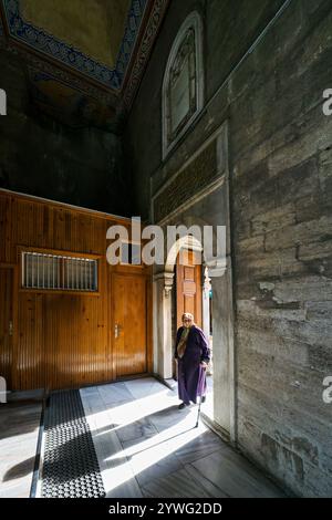 Donna anziana nel cortile della Moschea del Sultano di Eyup a Istanbul, Turchia Foto Stock