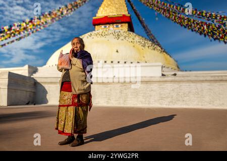 Donna buddista che prega di fronte a Boudhanath Stupa, Kathmandu, Nepal Foto Stock