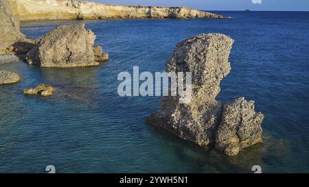 Grande roccia in acque blu calme, un impressionante elemento marino in condizioni climatiche limpide, colpo di droni, luce serale, spiaggia di Araki, costa sud-occidentale, Karpathos, Dodecan Foto Stock