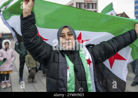 La donna siriana celebra la fine del regime di Assad dopo il cambio di potere in Siria in un raduno sulla piazza di fronte alla stazione ferroviaria principale di Foto Stock