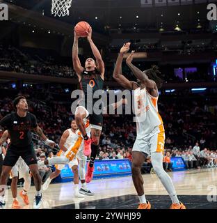 La guardia degli Hurricanes di Miami (FL) Matthew Cleveland (0) guida verso il basket contro l'attaccante dei Tennessee Volunteers Felix Okpara (34) durante il Jimmy V Classic al Madison Square Garden di New York City martedì 10 dicembre 2024. Duncan Williams/CSM Foto Stock