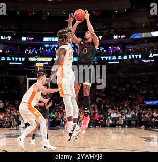 La guardia degli Hurricanes di Miami (FL) Matthew Cleveland (0) spara contro la guardia dei Tennessee Volunteers Jahmai Mashack (15) durante il Jimmy V Classic al Madison Square Garden di New York City martedì 10 dicembre 2024. Duncan Williams/CSM Foto Stock