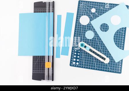 utensili e materiali per la lavorazione utilizzati per tagliare cerchi e strisce di carta. tappetino da taglio con griglia e vari cerchi di ritaglio di diverse dimensioni Foto Stock