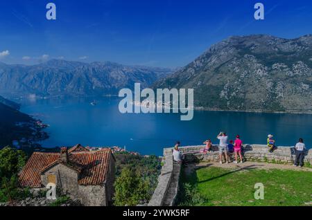 I turisti si godono e scattano foto delle viste panoramiche dal villaggio di Gornji Stoliv sulla baia di Cattaro in Montenegro Foto Stock