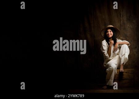 Una splendida modella femminile che sfoggia eleganza in una camicia e pantaloni in lino bianco. Una splendida donna che posa con sicurezza in un outfit tutto bianco Foto Stock