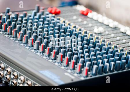 Primo piano del pannello di controllo del mixer audio con molti comandi Foto Stock