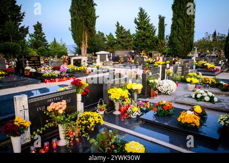 Autentico cimitero dalmata in Croazia con molti fiori e candele Foto Stock