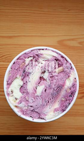 Gelato allo yogurt ai mirtilli in una grande tazza isolata su un tavolo di legno Foto Stock