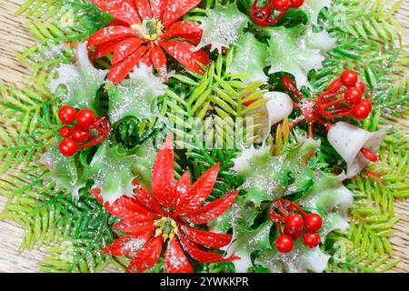 primo piano della decorazione del centrotavola in plastica natalizia degli anni '1960 con fiori di natale e fogliame Foto Stock