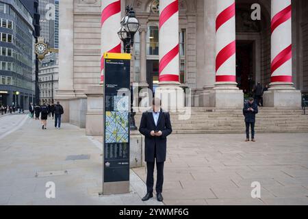 Settimane prima di Natale, i lavoratori della città si trovano fuori dal Royal Exchange, presso la Bank nella City di Londra, il distretto finanziario della capitale, l'11 dicembre 2024, a Londra, Inghilterra. Foto Stock