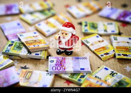 Weihnachtsmannfigur inmitten von Geldscheinen, Symbolfoto Weihnachtsgeld *** Babbo Natale, circondato da banconote, foto simboliche soldi di Natale Foto Stock