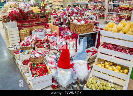 Vendita di giocattoli e decorazioni natalizie nel negozio: Palle rosse e dorate in cesto, noci e topi, statuette di nani, automobili, tamburi, caramelle ca Foto Stock