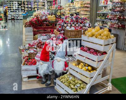 Vendita di giocattoli e decorazioni natalizie nel negozio: Palle rosse e dorate in cesto, noci e topi, statuette di nani, automobili, tamburi, caramelle ca Foto Stock