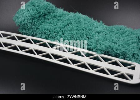 Splendido tessuto verde morbido e morbido in nylon sintetico con base in plastica bianca, impugnatura per pulire e pulire la stanza dalla polvere. Foto Stock