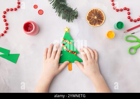 Albero di Natale di carta con perline colorate idee artigianali di carta per bambini per l'asilo Foto Stock