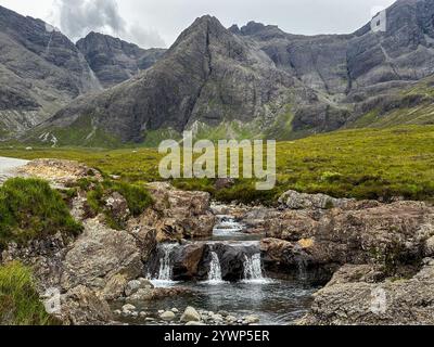 L'eterea bellezza delle piscine delle fate sotto le maestose montagne Skye della Scozia. Foto Stock