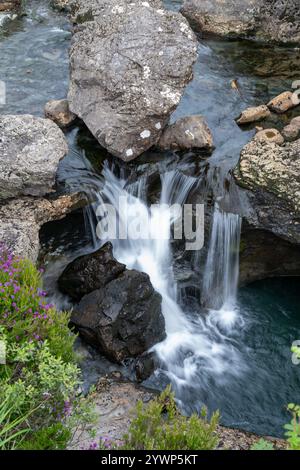 L'eterea bellezza delle piscine delle fate sotto le maestose montagne Skye della Scozia. Foto Stock