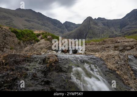 L'eterea bellezza delle piscine delle fate sotto le maestose montagne Skye della Scozia. Foto Stock
