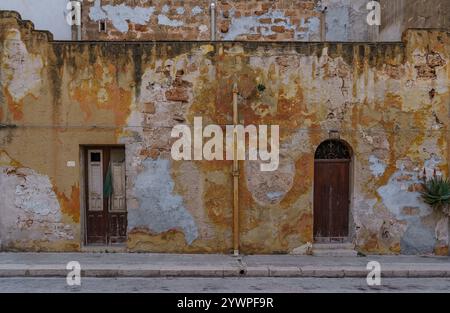 Pareti molto vecchie e fatiscenti con porte vecchie che nessuno sta ristrutturando. Foto Stock