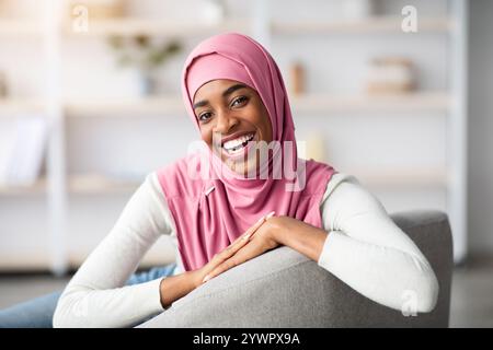 Allegra bella donna musulmana nera in hijab in posa in casa interno Foto Stock