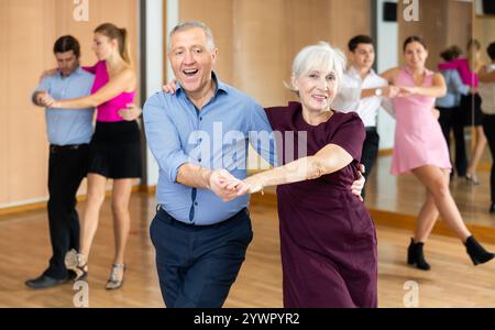 Allegra coppia anziana che pratica danze da ballo nella sala da ballo Foto Stock