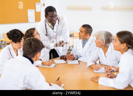 Operatori medici che ascoltano il docente afro-americano durante il corso di formazione professionale Foto Stock