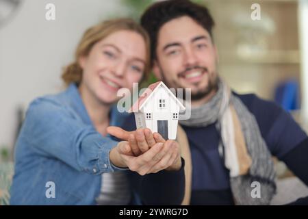giovane coppia amorevole che tiene una piccola casa modello Foto Stock