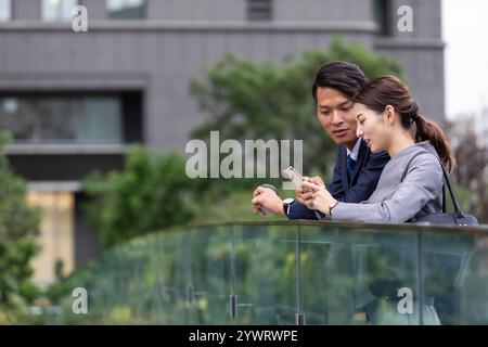 Uomini e donne d'affari che guardano gli smartphone Foto Stock