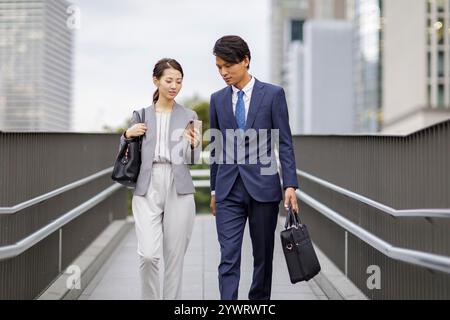 Uomini e donne d'affari che guardano gli smartphone Foto Stock