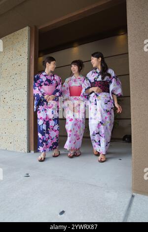 Tre giovani donne nello yukata che camminano all'interno di una locanda Foto Stock