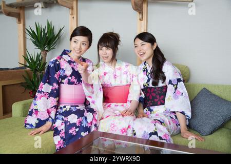 Tre giovani donne che si rilassano all'interno di un ryokan nello yukata Foto Stock