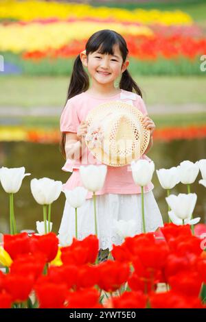 Tulipani in piena fioritura e una ragazza con un cappello Foto Stock