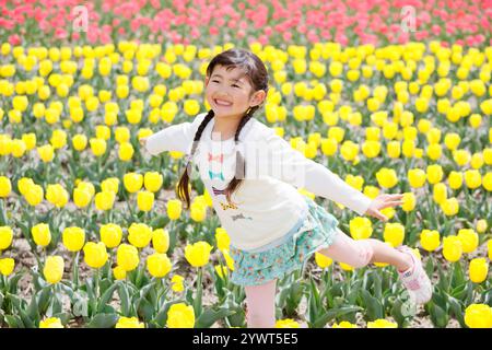 Ragazza che ride nel campo dei tulipani Foto Stock