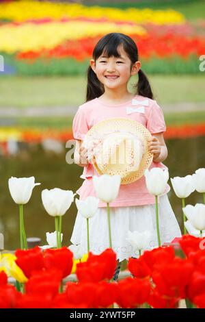 Tulipani in piena fioritura e una ragazza con un cappello Foto Stock