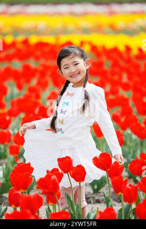 Ragazza che ride nel campo dei tulipani Foto Stock