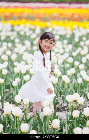 Ragazza che ride nel campo dei tulipani Foto Stock