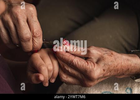Una nipote e sua nonna si tagliano le unghie Foto Stock